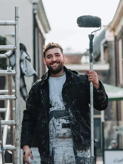 Vince Heuckeroth met verfroller voor de steiger bij een klus